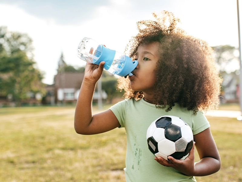 girl drinking water on the park