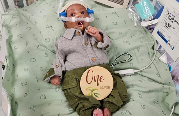 A small baby intubated on a hospital stretcher