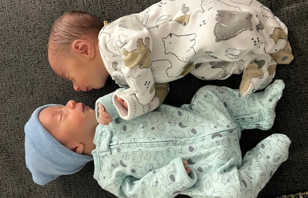 Two babies lying down facing each other.
