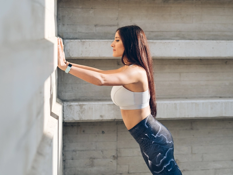 athletic woman doing exercises against the wall