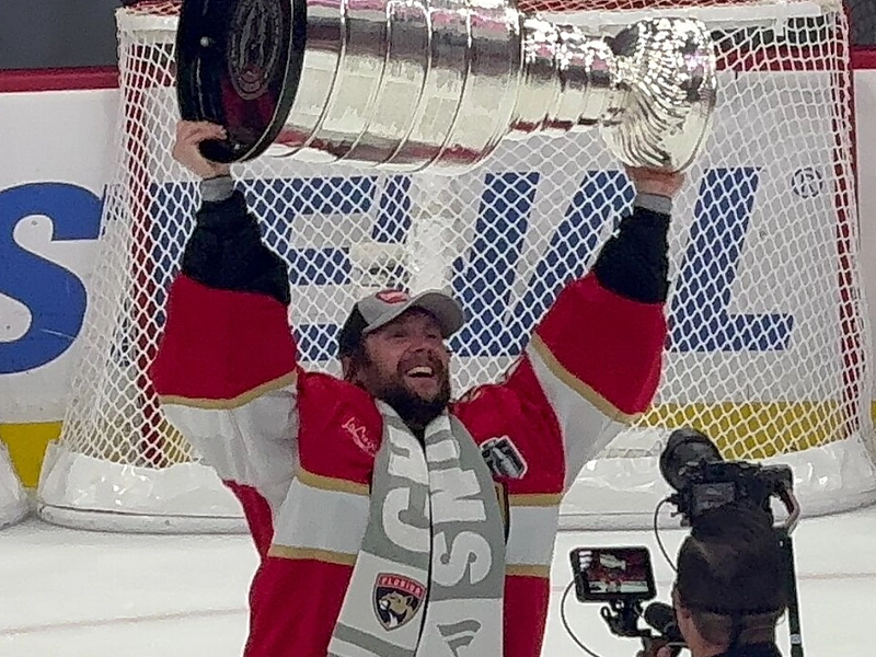 hockey player raising a giant silver cup