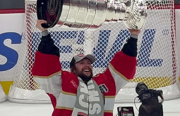 hockey player raising a giant silver cup