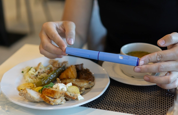 Close-up of hands holding a medical test in front of a plate of food.
