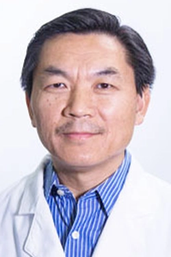 Headshot of a medical professional, he smiles at the camera