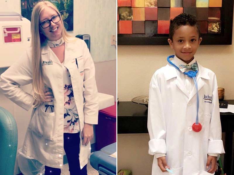 A physician on the left smiling, she has long blonde hair and wears a white coat. A young boy on the right, he wears a white coat and smiles.