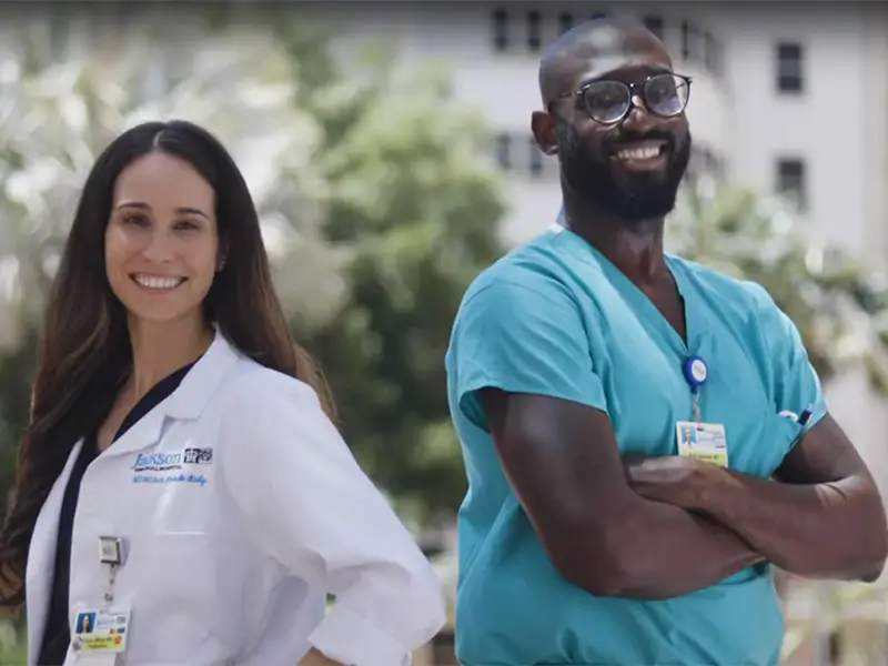 two doctors smiling and posing at the camera
