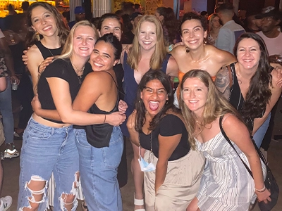 large group of women hugging each other while smiling