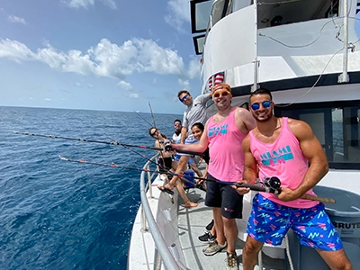 men in pink t-shirts posing from yacht