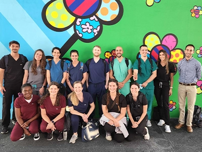 group photo of people posing with beautiful painting behind them