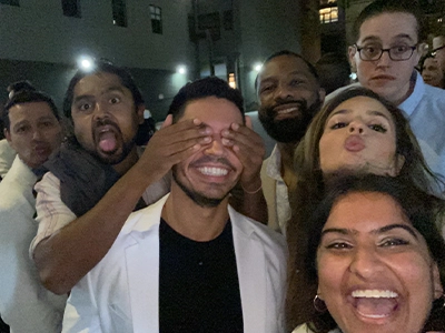 group photo in which one of the people's eyes are covered