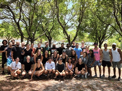 group of people posing and smiling at camera outdoors