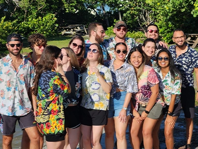 group of people in beach clothes posing and smiling at the camera