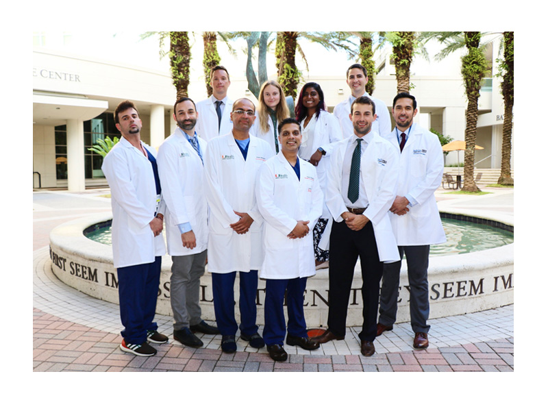 Multiple GME faculty and students posing in front of a camera