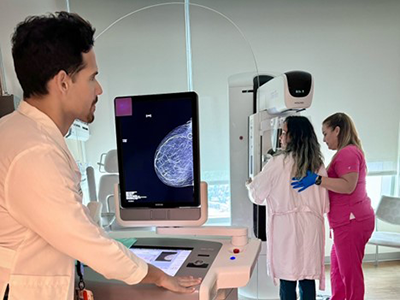 Medical professionals performing breast imaging on a patient