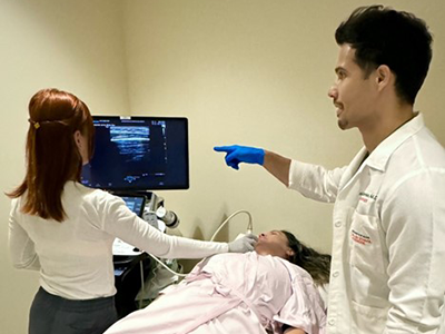 Medical professionals performing breast imaging on a patient