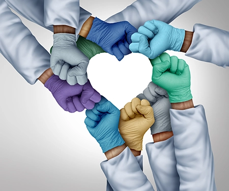 8 arms with closed fists forming a hand; you only see part of each arm, each arm has on different colored medical gloves and white long sleeves