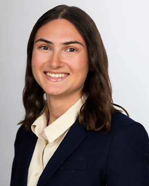 Close-up of a woman in a suit smiling at the camera.