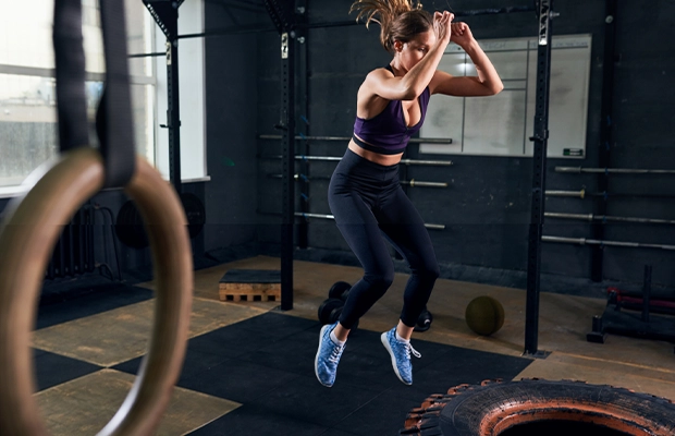 Photograph of a woman jumping in a gym.