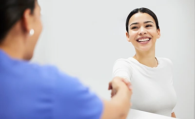A closeup of a woman shaking a medical professionals hand