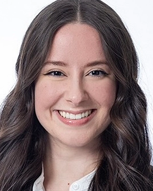 Close-up of a woman in a suit smiling at the camera.