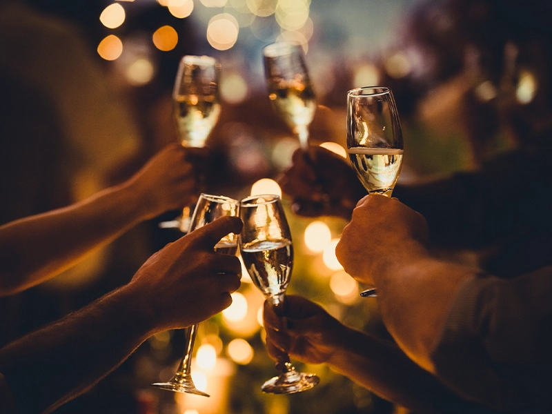 Close-up of hands toasting with glasses