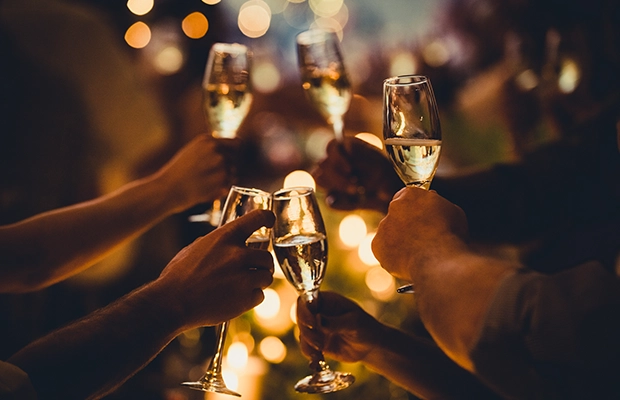 Close-up of hands toasting with glasses