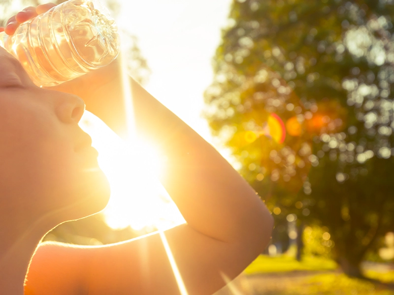 Close-up of a person's face bathed in sunlight in a park.