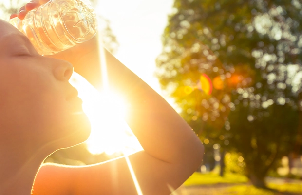 Close-up of a person's face bathed in sunlight in a park.