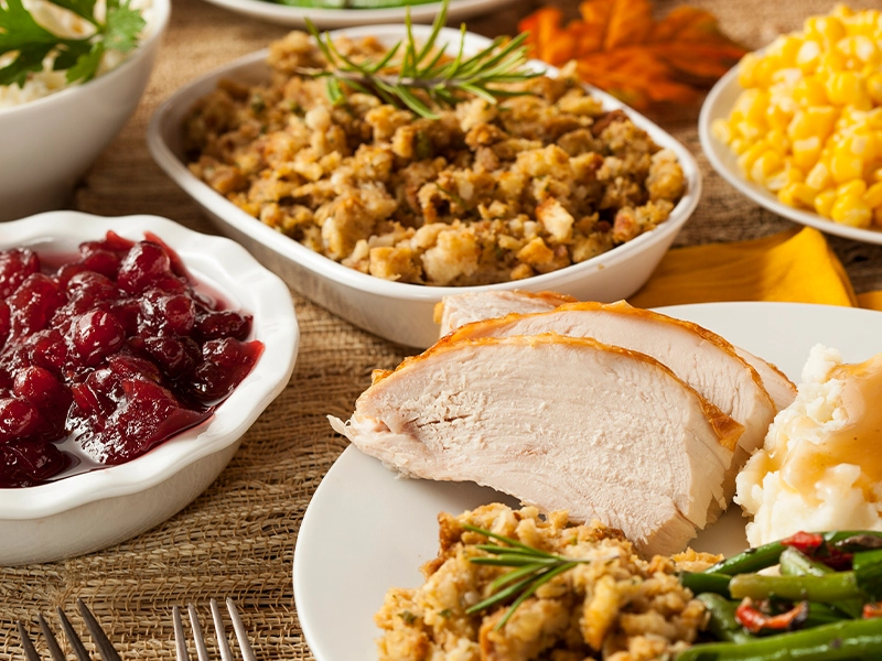 Close-up of a table full of food, including chicken, beans, corn, and other items