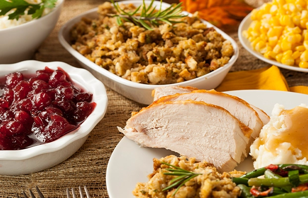 Close-up of a table full of food, including chicken, beans, corn, and other items