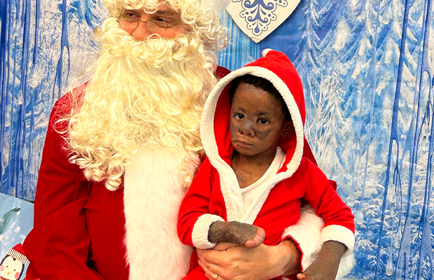 boy sitting on santa claus legs