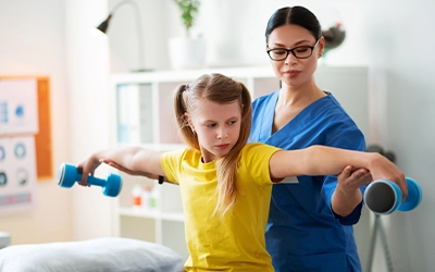 Girl undergoing physical therapy with her doctor.
