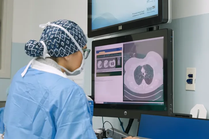 A medical professional looking at a screen