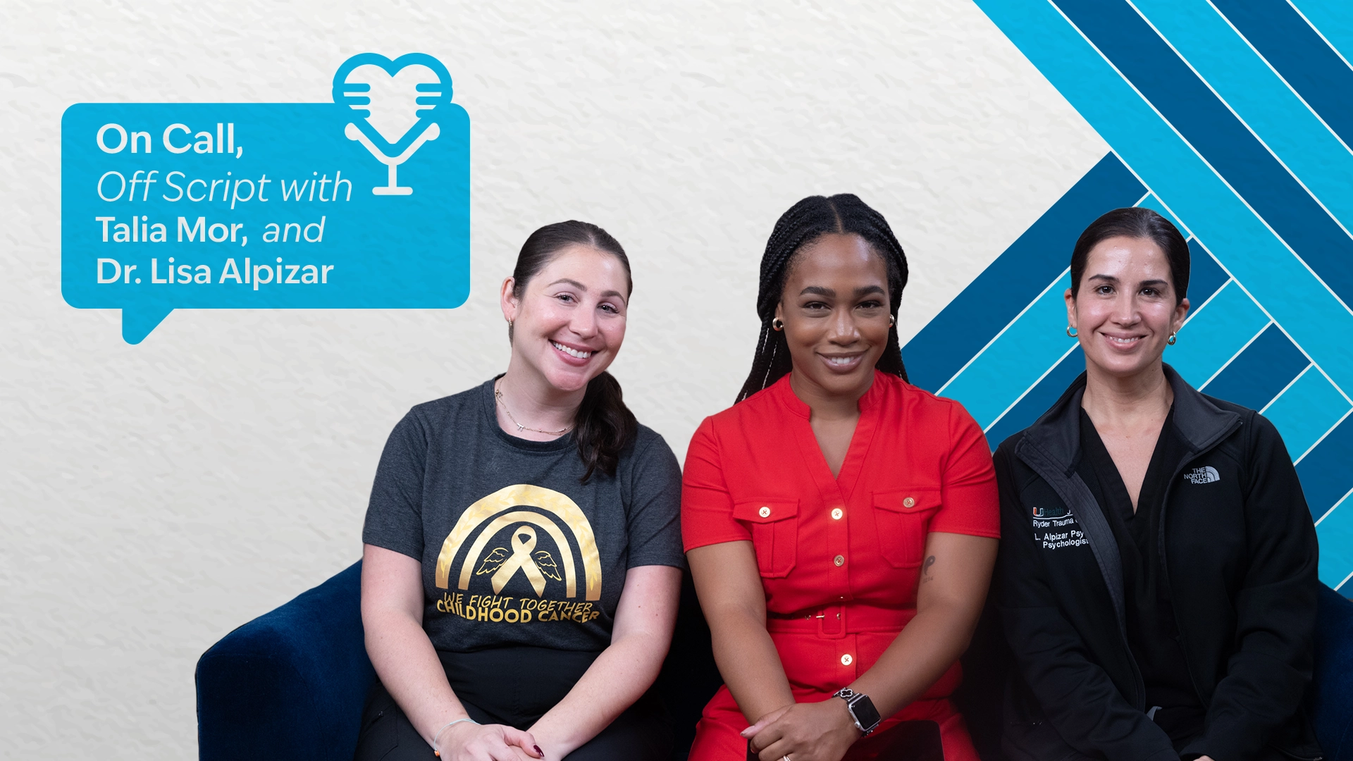 Three women sitting, posing, and smiling at the camera with a blue background behind them.