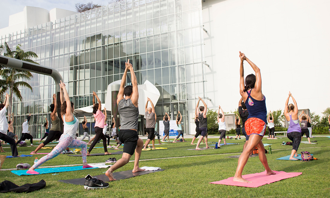 Group of people doing yoga outside on grass