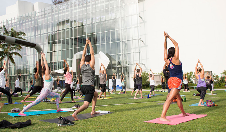 Group of people doing yoga outside on grass