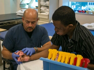 Male medical worker rehabbing a burn victims right arm