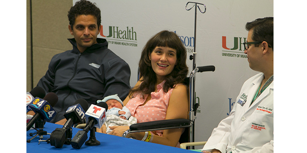 Maria and her husband at a press conference, looking at a doctor.