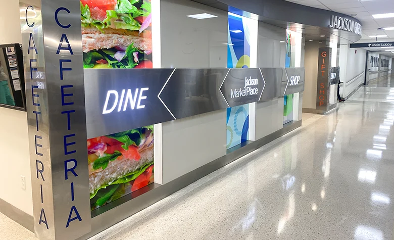 An external image of a cafeteria entrance, you see a hallway to the right