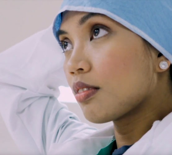 A doctor putting on a hair cover