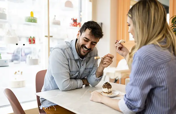 Two people eating dessert at a cafe