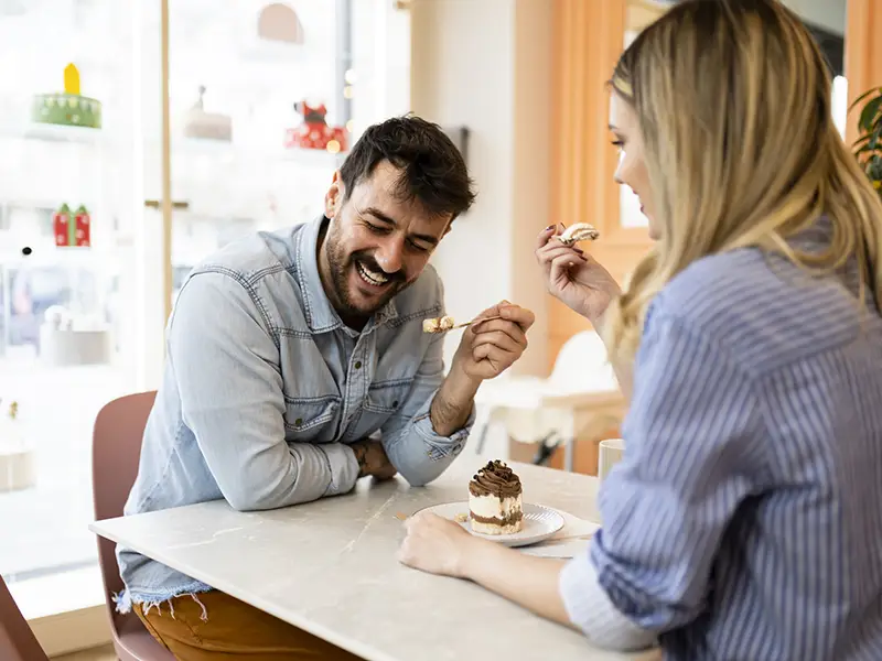 Two people eating dessert at a cafe
