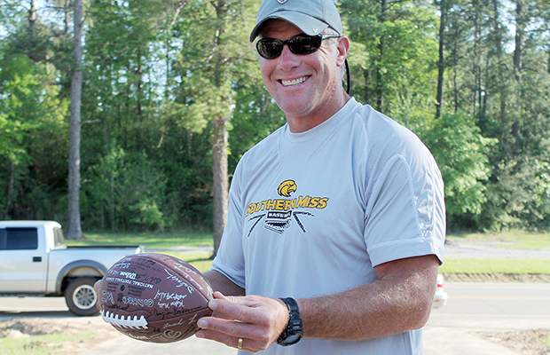 An image of a man holding a football that's signed, he is wearing a hat, gray shirt, and is smiling at the camera. Get this image on Flickr. https://www.flickr.com/photos/wiguardpics/6921762056