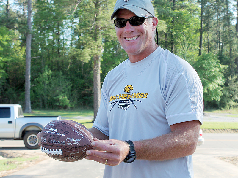 An image of a man holding a football that's signed, he is wearing a hat, gray shirt, and is smiling at the camera. Get this image on Flickr. https://www.flickr.com/photos/wiguardpics/6921762056