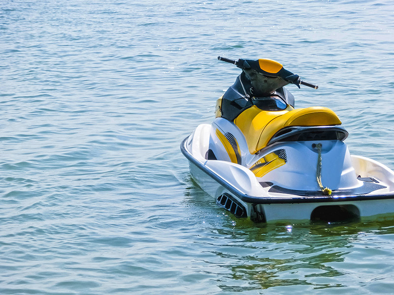 A yellow jet ski floating in the ocean