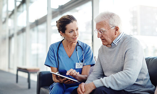 Physician showing an older male patient a chart with options
