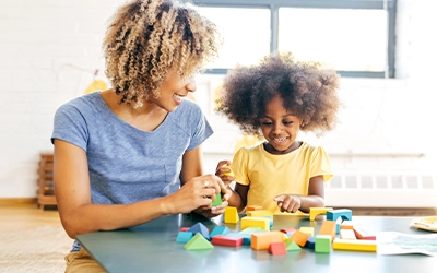 Mother and daughter playing with colored blocks