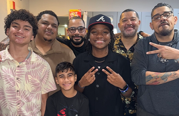 Six men and a boy posing and smiling at the camera.