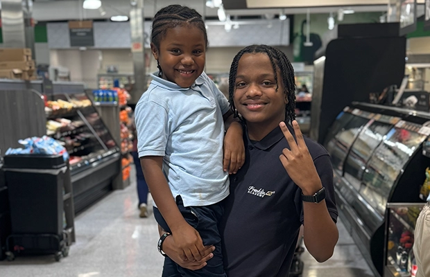 young boy lifting up a little girl