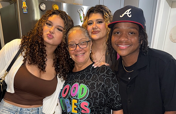 four people posing and smiling at the camera